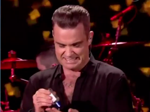 Robbie Williams y su cara de desagrado tras tocar a fanática