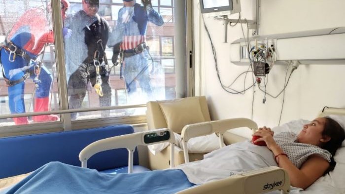 Arriba del andamio: Limpiadores de vidrios vestidos de superhéroes sorprendieron a niños internados en clínica