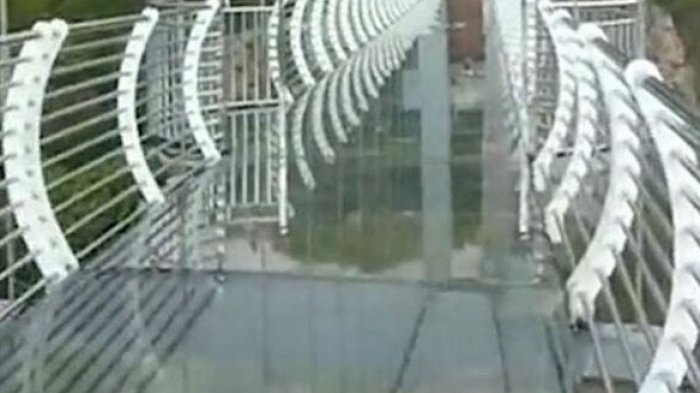 Foto muestra cómo un turista se aferra por su vida a 100 metros de altura: Puente de vidrio colapsó