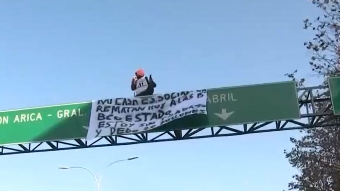 Hombre trepó a una señalética en Santiago para protestar por remate de su casa